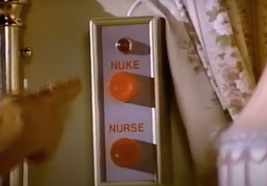 Image of a finger reaching twoards two big red buttons marked "nuke" and "nurse" with the finger headed towards "nuke"